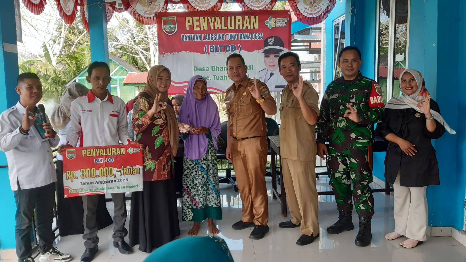 BLT; Kades Dharma Sakti Erlina Feridawati disaksikan Camat Tuah Negeri, Achmad Charles dan pendamping desa membagikan BLT-DD Tahap 2 Tahun 2025, Selasa 10 Juni 2025.